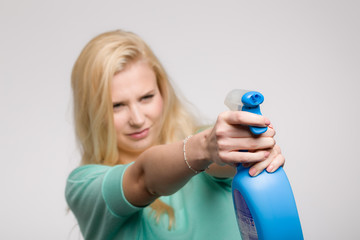 Junge blonde Frau mit Reinigungsmittel