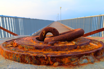 Rusted iron anchorage in afternoon light with long 