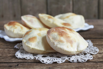 Pita bread on a wooden table. Rustic style and selective focus.