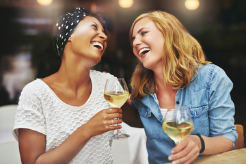 Two young female friends celebrating and laughing - obrazy, fototapety, plakaty