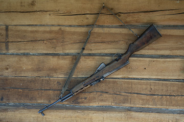 Gun on the wall of the wooden house.