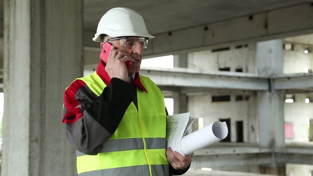 Civil engineer with cell phone at construction site