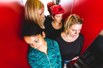 Vier Frauen im engen Fahrstuhl