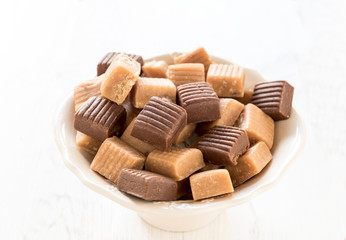 Mix of caramel bonbons in the bowl,selective focus