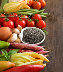 Raw chia seeds in bowl and vegetables