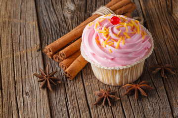 Colored cupcake on rustic background
