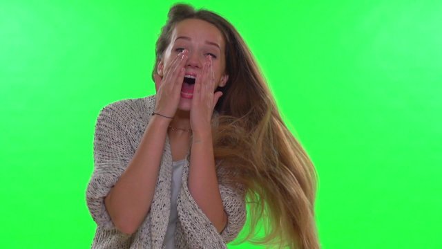 Young beauty surprised girl rejoices on green screen