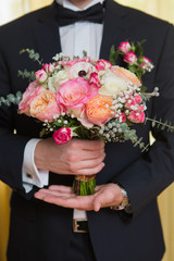 Wedding bouquet in groom hand