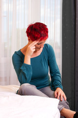 gestresste Frau sitzt auf dem Bett im Hotelzimmer