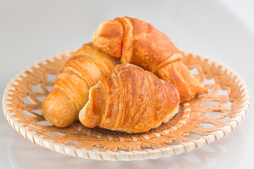 Croissants in wicker wooden plate