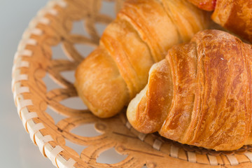 Croissants in wicker wooden plate