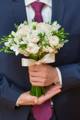 Obraz na płótnie Canvas Wedding bouquet in groom hand