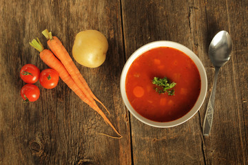 Vegetables soup with fresh vegetable on a rustic table