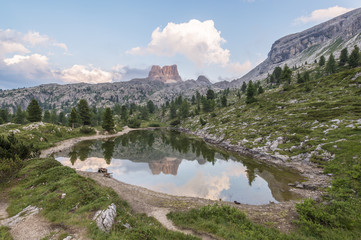 Fascinating reflections of the Dolomites mountains in lake Limedes at Sunset. Vivid and bright colors of the dramatic evening.