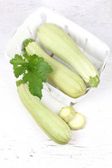 Fresh sliced marrow vegetable in basket. Isolated on white background 