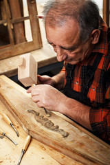 Close-up of senior carpenter restoring old furniture