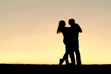 Fototapeta na wymiar Silhouette of Happy Young Couple Dancing at Sunset
