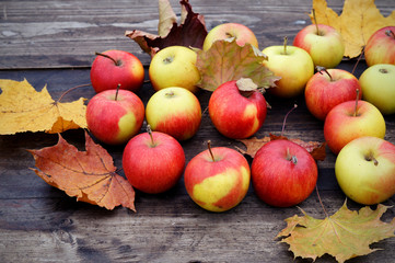 Apples with autumn leaves on wooden table