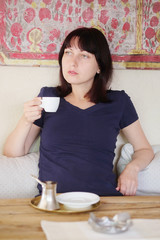 Girl drinks coffee in a cafe