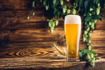 Sierkussen Glas bier op oude houten tafel en houten achtergrond © nioloxs