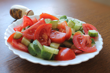 Still life. Salad with tomatoes and cucumbers on the dish.