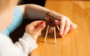 girl feeding handmade chestnut animal toy
