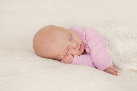 Neugeborenes Baby schläft zufrieden und zugedeckt