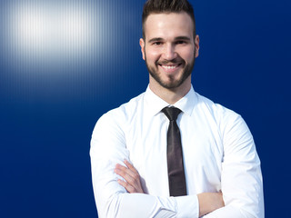 Businessman in front of blue background smiling