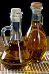 Two bottles of olive oil on rustic table