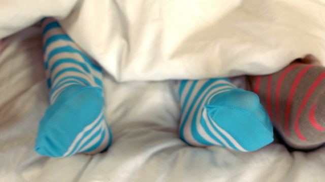 Feet of a family in the bed