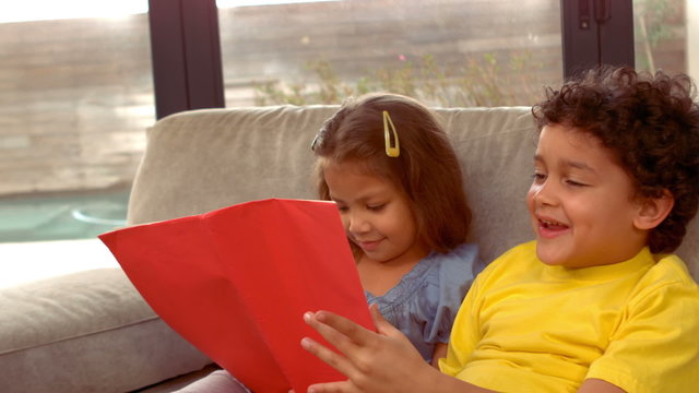 Hispanic children reading together a book