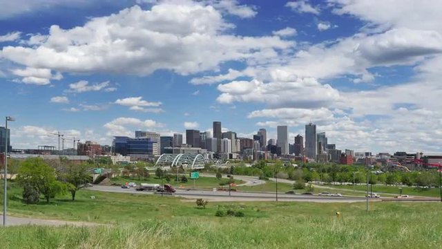 Wide angle view of the Denver skyline, with Interstate traffic in the foreground, and active clouds above. 4K UHD time lapse.