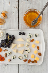 Cheese and fruit mix on the white ceramic plate