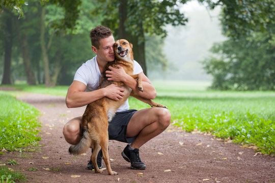 young man with dog in park