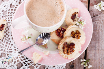 Shortbread cookies with white chocolate and walnuts and a Cup of coffee with milk.