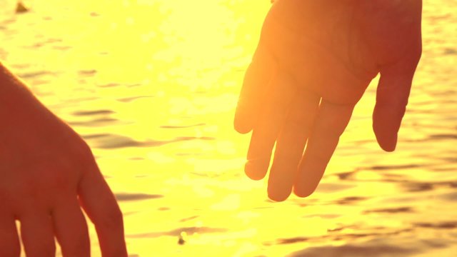 Couple holding hands over blinking sea background