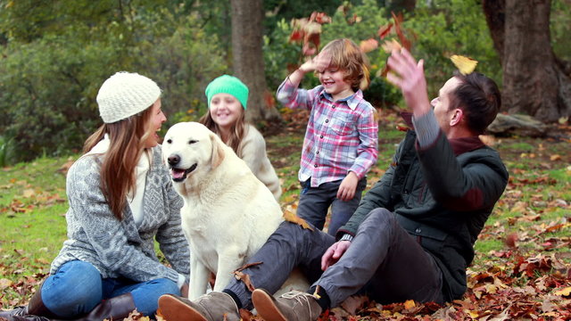 Family with their dog on autumns day in park