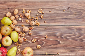 Fototapeta na wymiar Apples and nuts on a wooden table