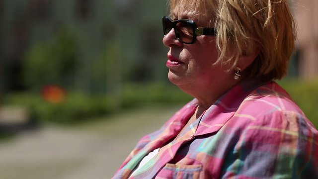 Senior woman with glasses smoking a cigarette