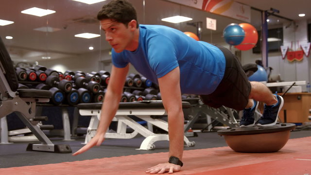 Man doing plank position on bosu ball