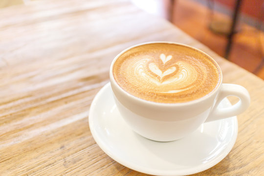 Fototapeta Cup of coffee latte art on wood table