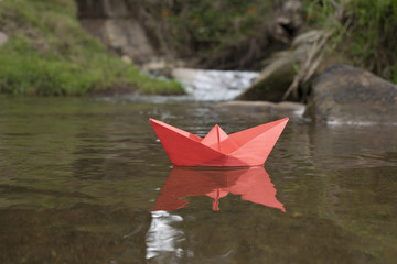 Barco de papel de colores sobre agua