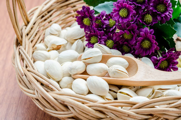 Pistachio and wooden spoon in weave basket.