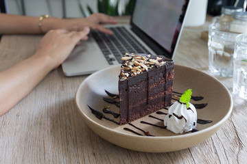 cake chocolate on wood table work with laptop notebook computer