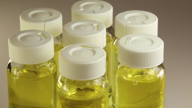 Seven rotating bottles with yellow liquid