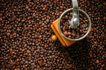 Hand grinder on roasted coffee beans background