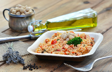 Couscous-Salat - Taboulé, in Teller auf Holztisch / Rustikal mit Besteck