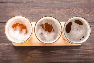 Papier Peint photo autocollant Bière Assortiment de verres à bière sur un fond en bois. Vue de dessus