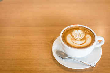 Hot art Latte Coffee in a cup on wooden table and Coffee shop bl