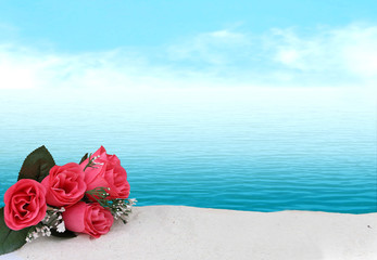 bunch of roses on sea sand with blur ocean background